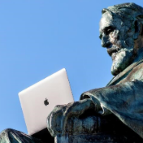 The statue of Ezra Cornell holds a laptop